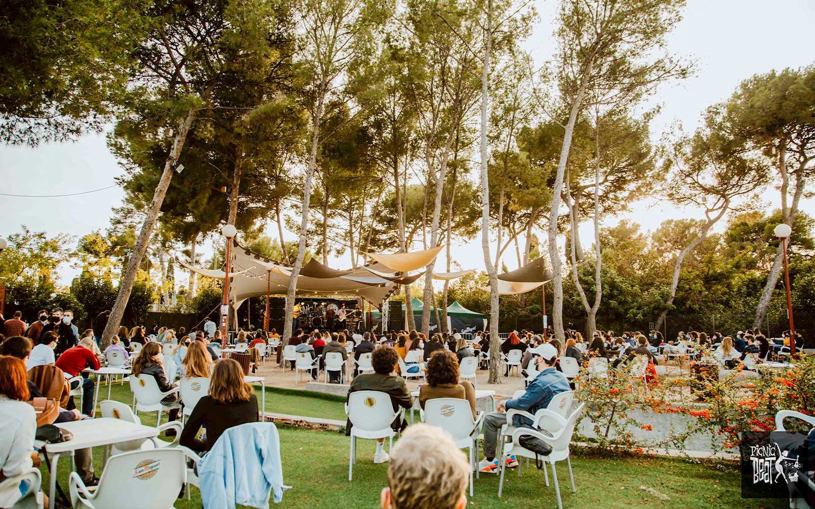 Tourists enjoying food at an outdoor concert in Poble Espanyol, Barcelona.