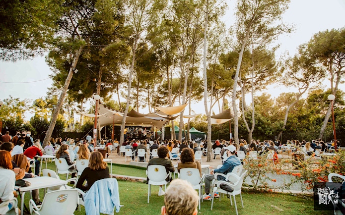 Tourists enjoying food at an outdoor concert in Poble Espanyol, Barcelona.