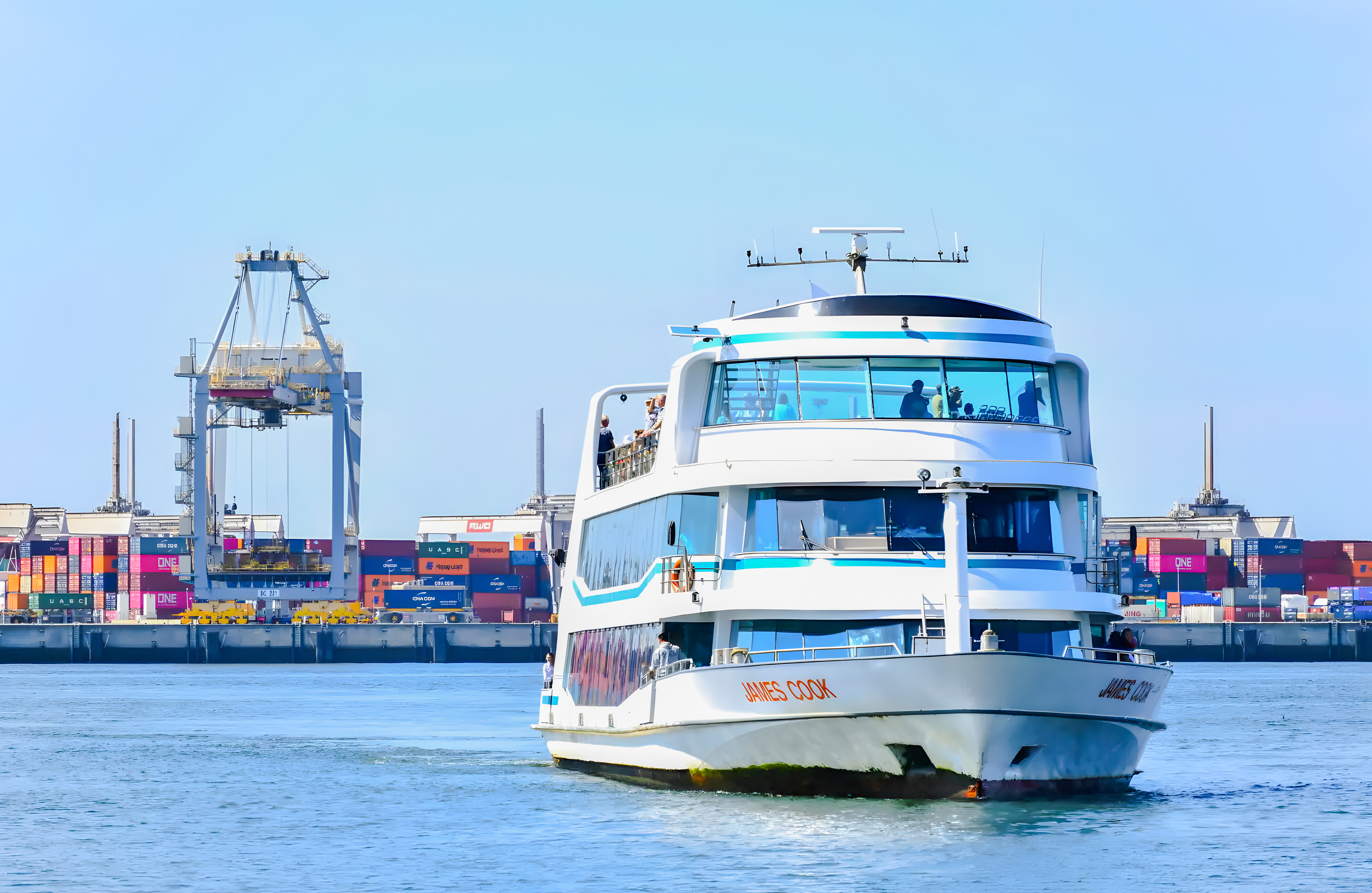 Cruise ship in Rotterdam harbor with shipping containers and cranes in the background.