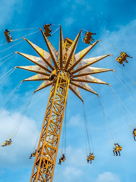 Parc Astérix swing ride with people enjoying the aerial view.