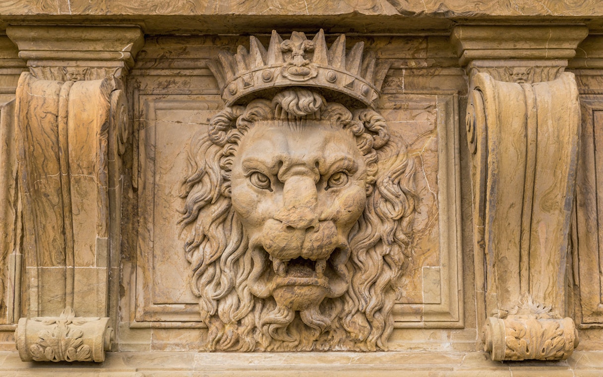 Stone lion sculpture with crown at Pitti Palace, Florence.