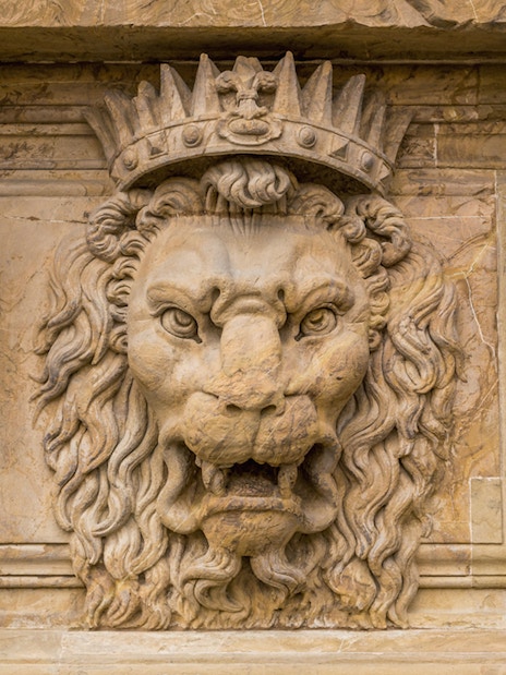 Stone lion sculpture with crown at Pitti Palace, Florence.