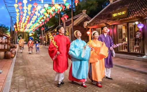 Performers in traditional Vietnamese attire under colorful lanterns at The Quintessence of Vietnam Show.