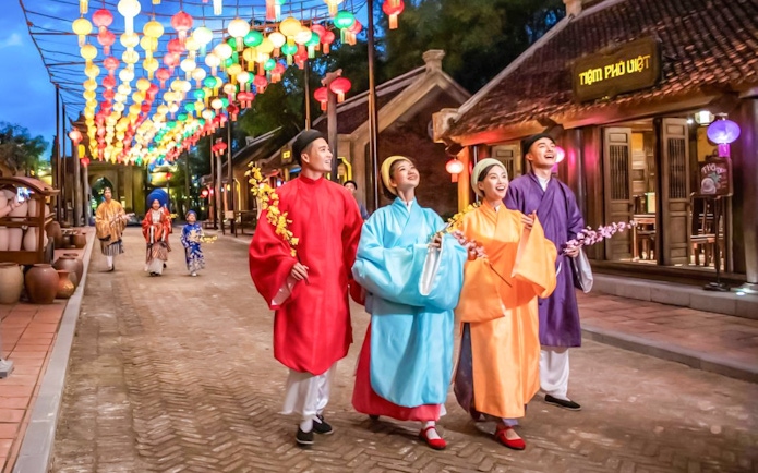 Performers in traditional Vietnamese attire under colorful lanterns at The Quintessence of Vietnam Show.