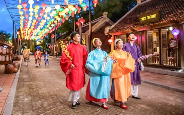 Performers in traditional Vietnamese attire under colorful lanterns at The Quintessence of Vietnam Show.