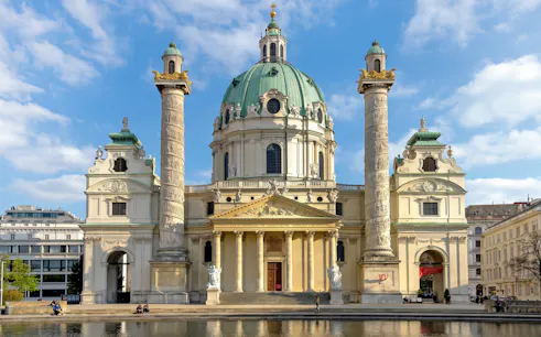Karlskirche in Vienna with its iconic dome and columns, viewed from the front.