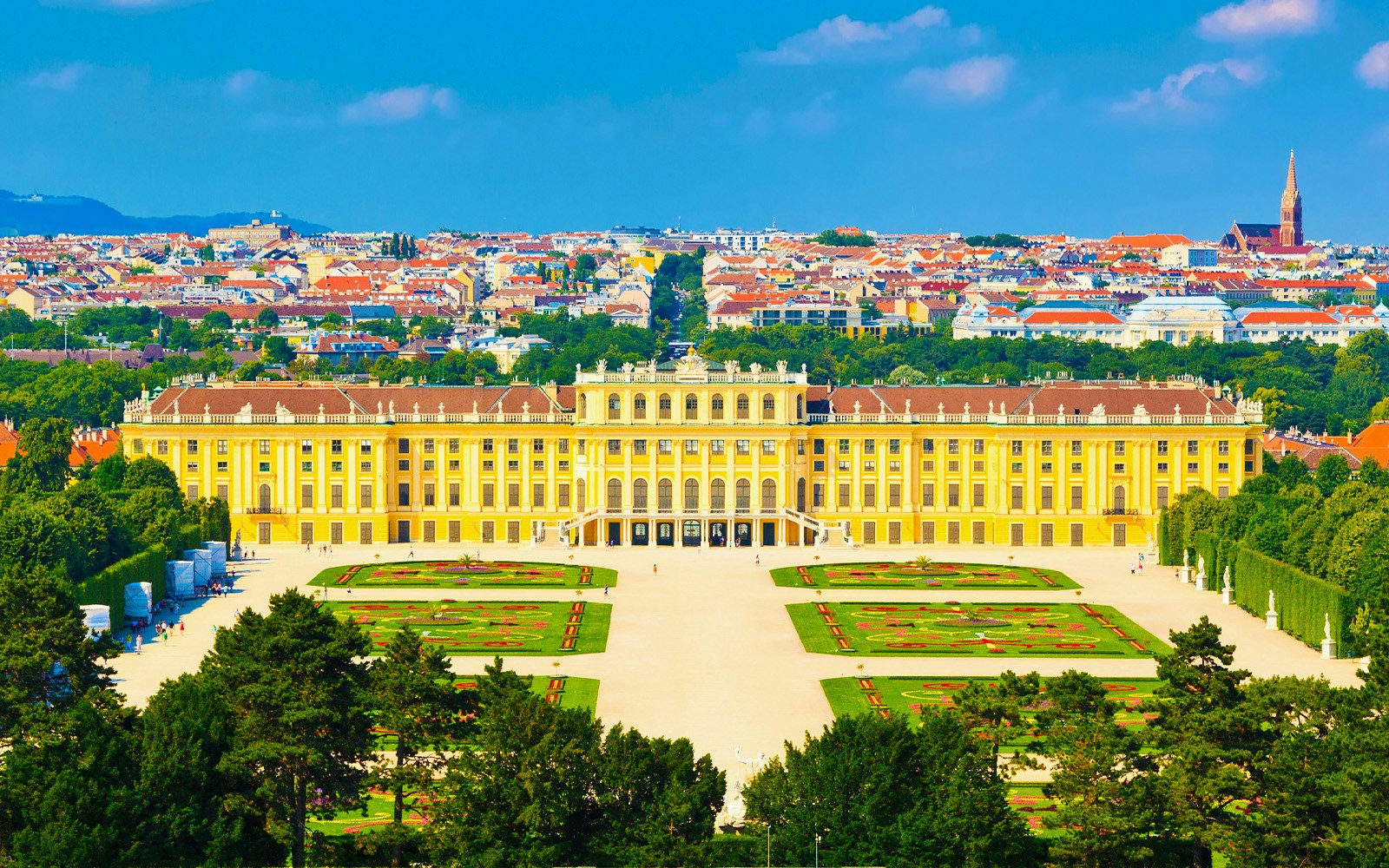 Schönbrunn Palace in Vienna with gardens and cityscape in the background.
