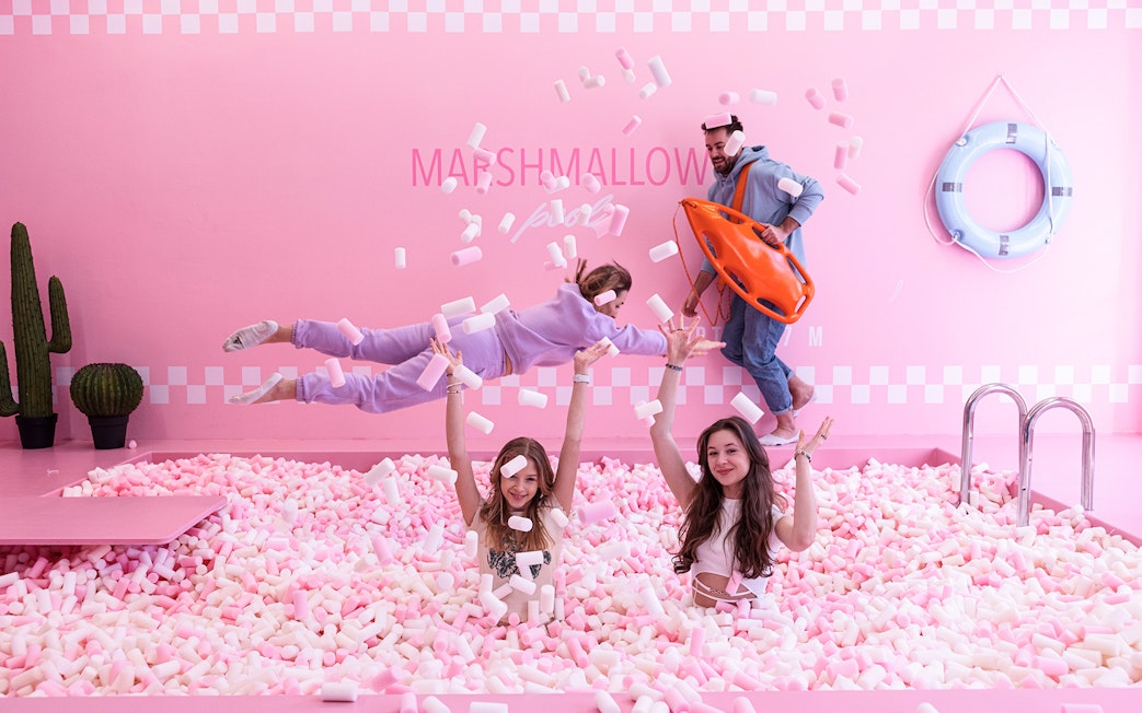 Tourists playing in marshmallow pool at Happy Museum, Warsaw.