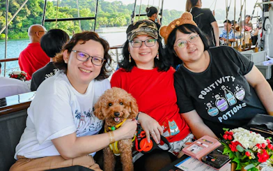 Three people and a dog on the Royal Albatross breakfast cruise.