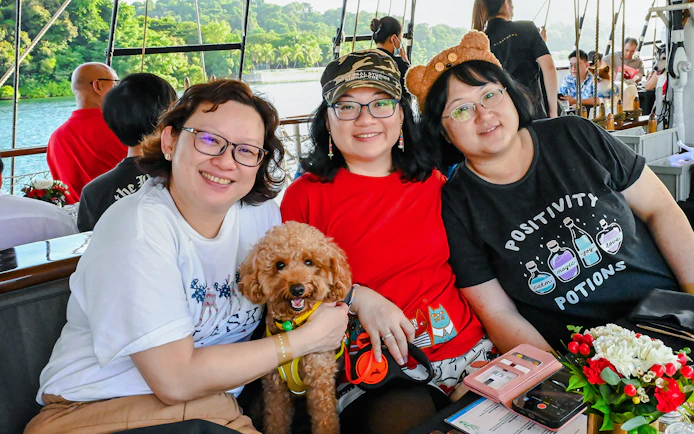 Three people and a dog on the Royal Albatross breakfast cruise.