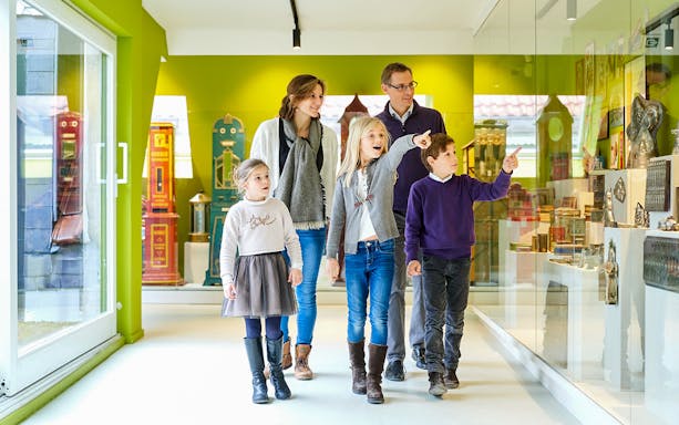 Family exploring exhibits at Choco Story Brussels museum.