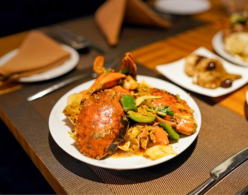Crab dish with vegetables on a plate at a restaurant in Singapore.