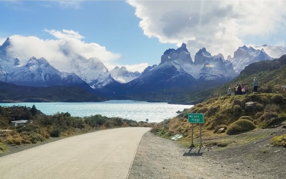 Road leading to Torres del Paine National Park with mountains and Lago Pehoé, Chile.