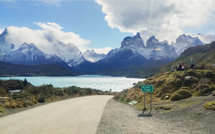 Road leading to Torres del Paine National Park with mountains and Lago Pehoé, Chile.