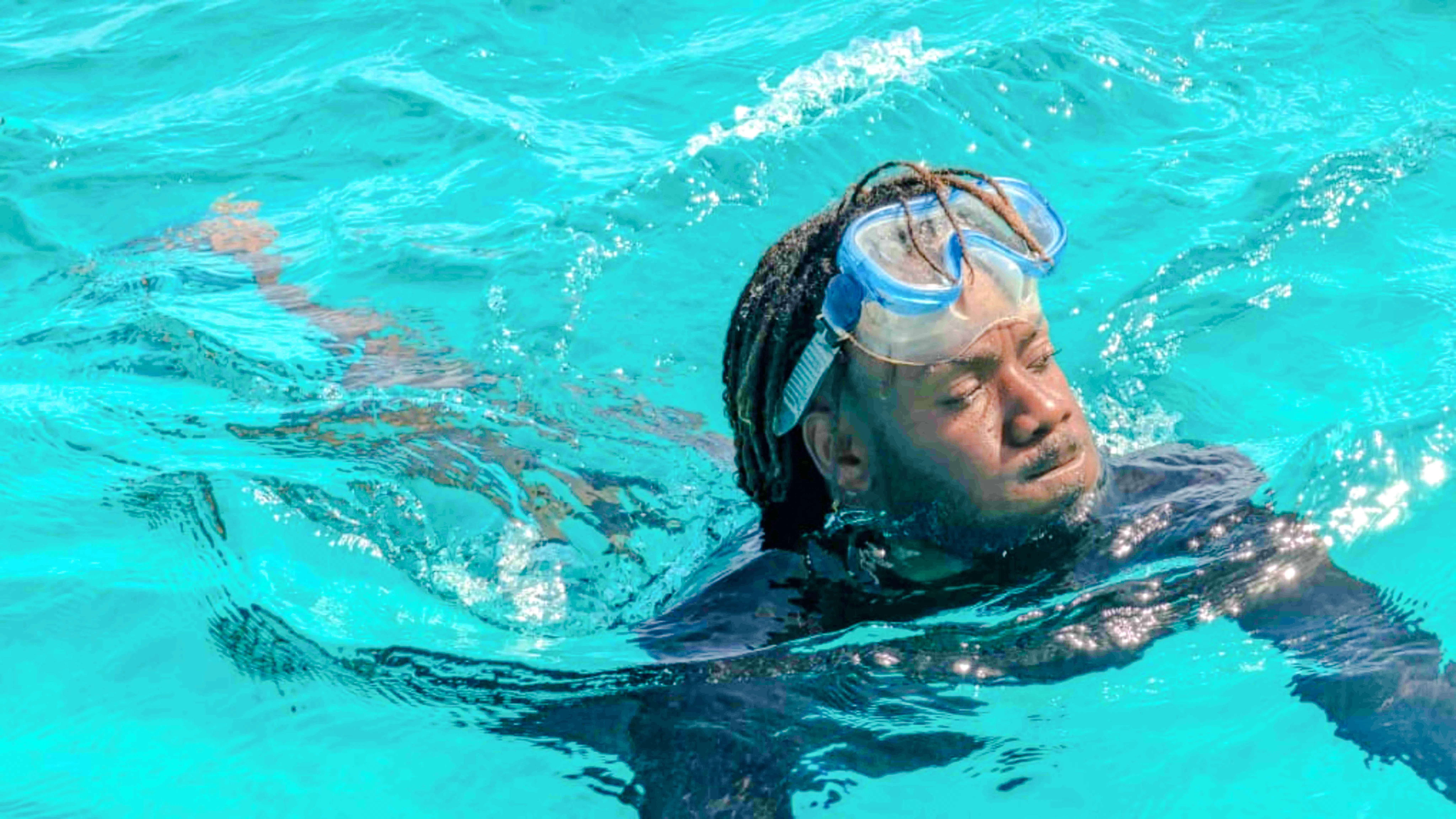 Snorkeler in clear blue waters during Mnemba snorkeling tour, Zanzibar.
