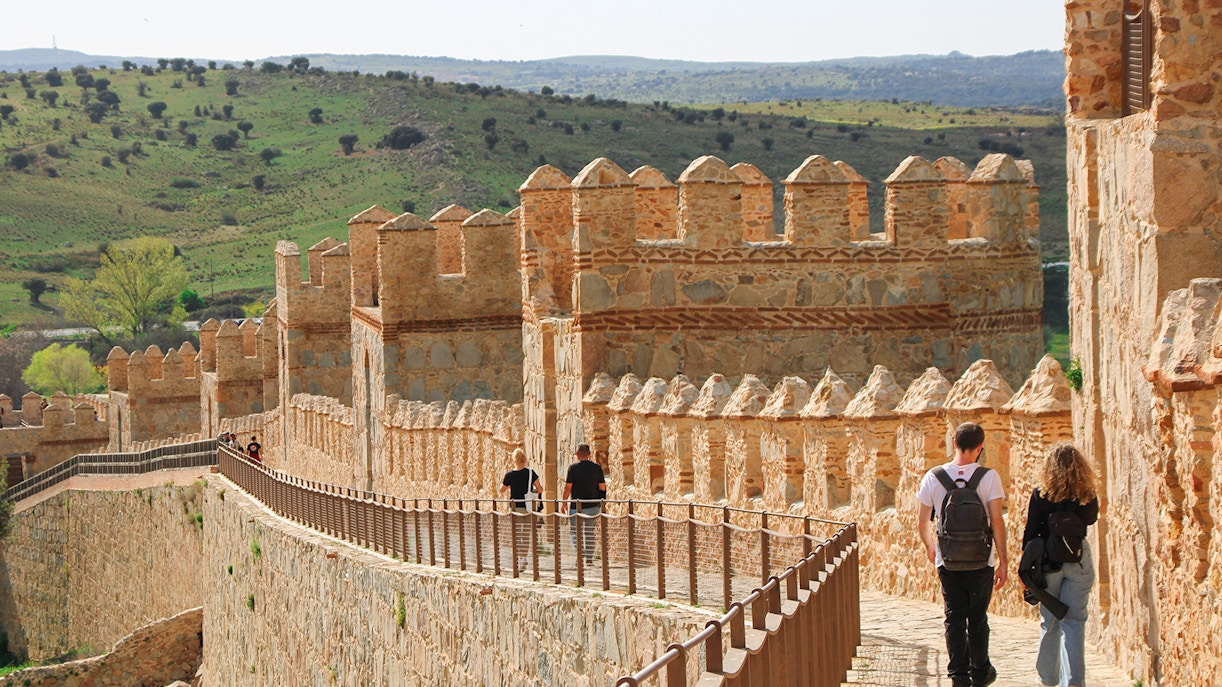 Visitors walking along the historic Avila Wall during a tour from Madrid.