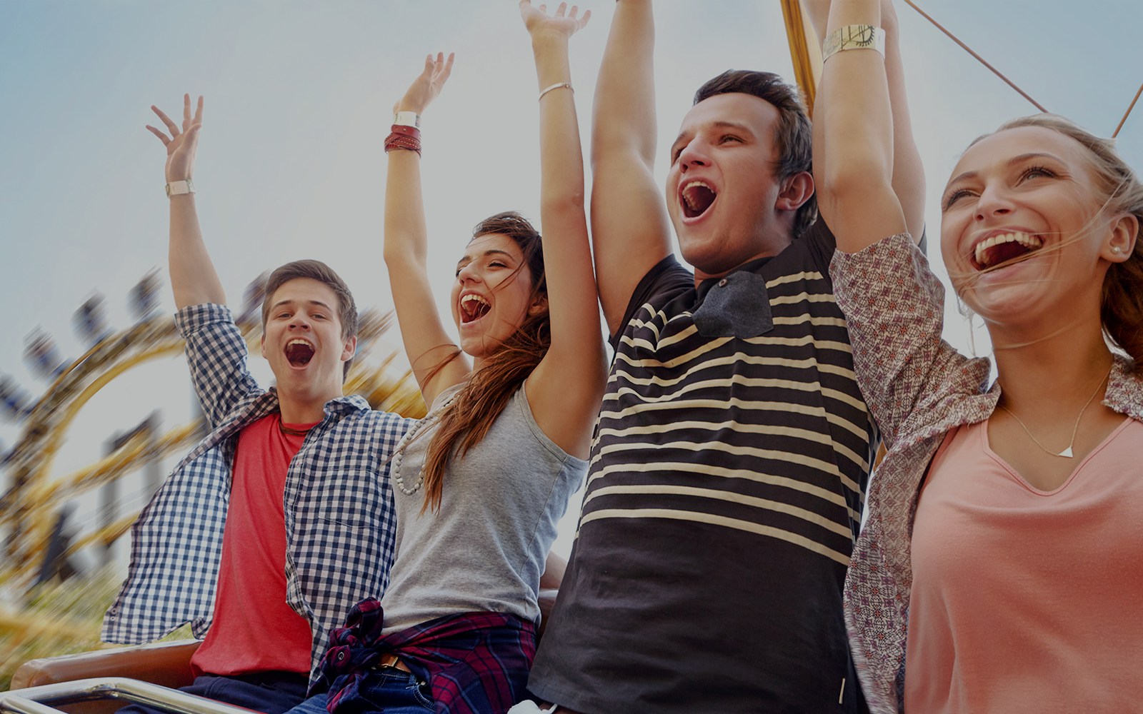 Friends enjoying a roller coaster ride at an amusement park.