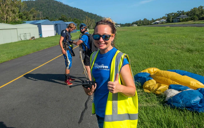 Skydiving team preparing for tandem jump at Airlie Beach runway.