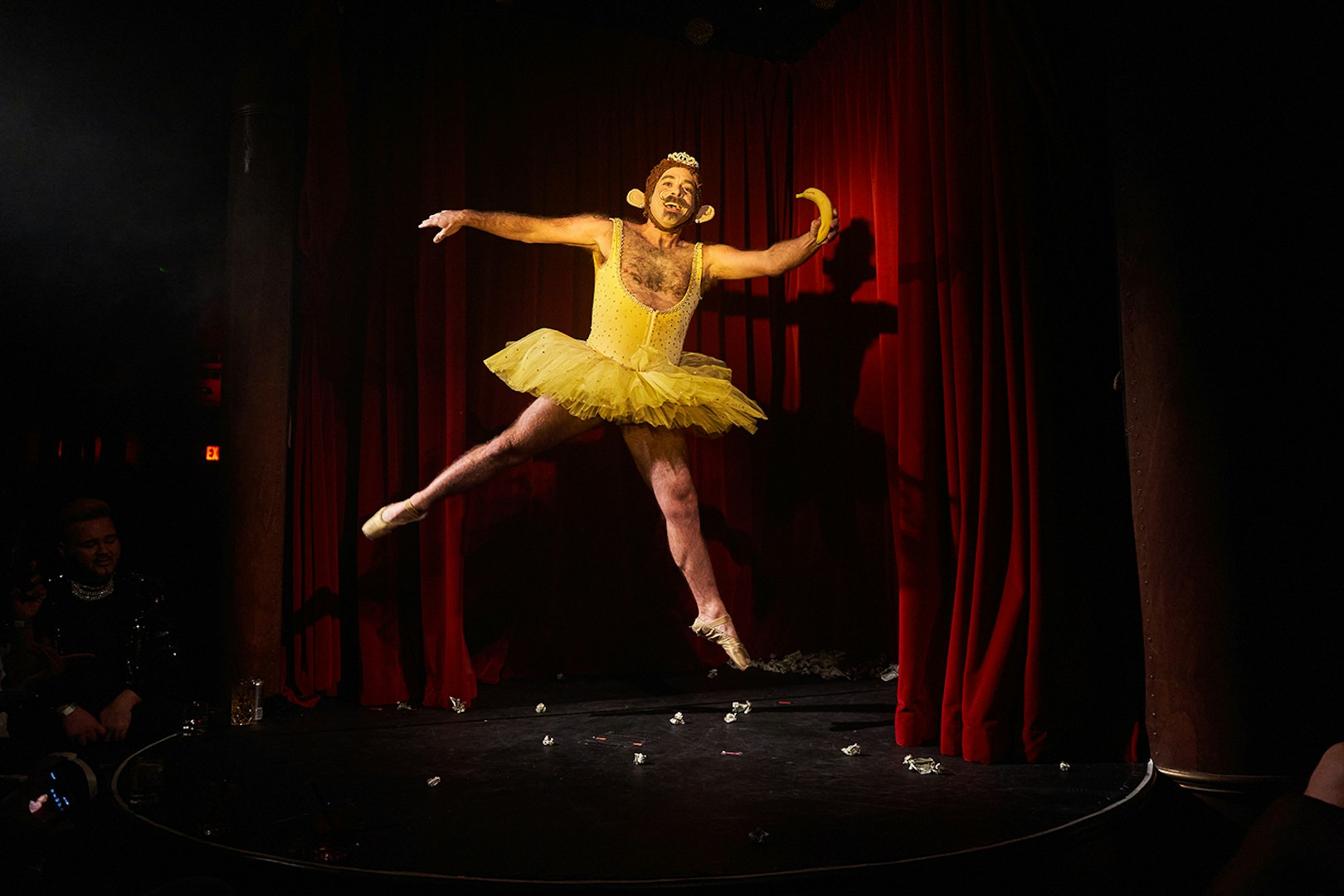 Performer in yellow tutu dancing on stage at Miss Behaves: Maverick's Variety Show.