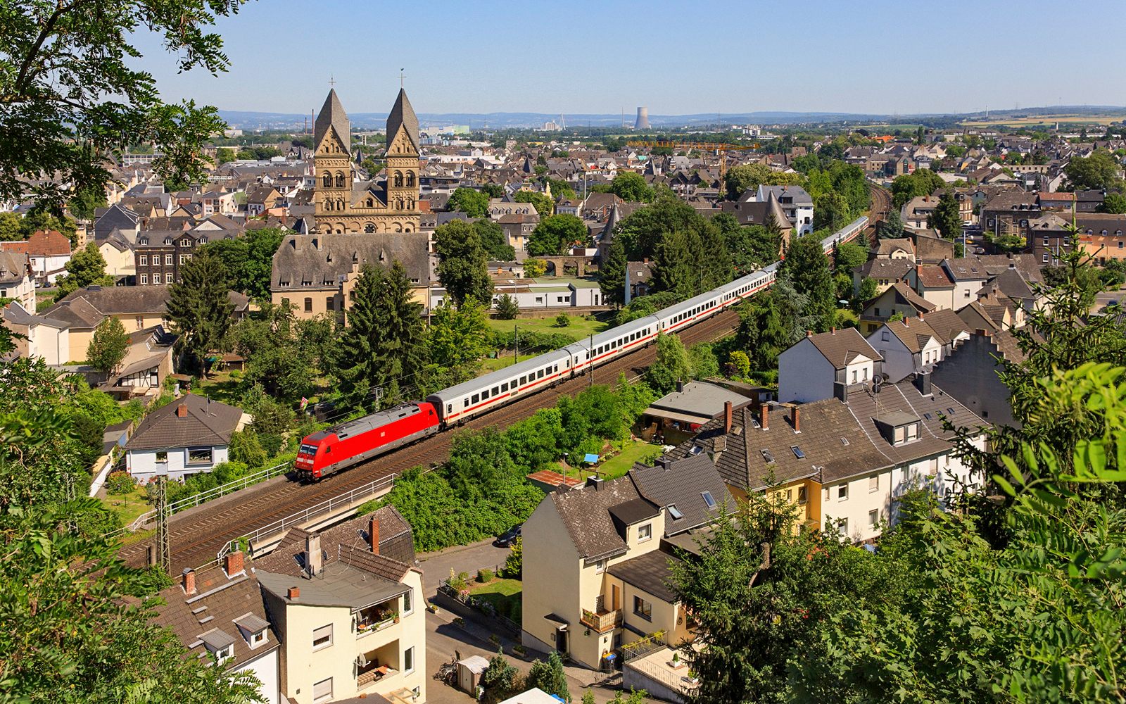 Intercity train passing through a German town with historic church in the background.