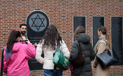 Tour group at Holocaust memorial in Haarlem during WWII walking tour.