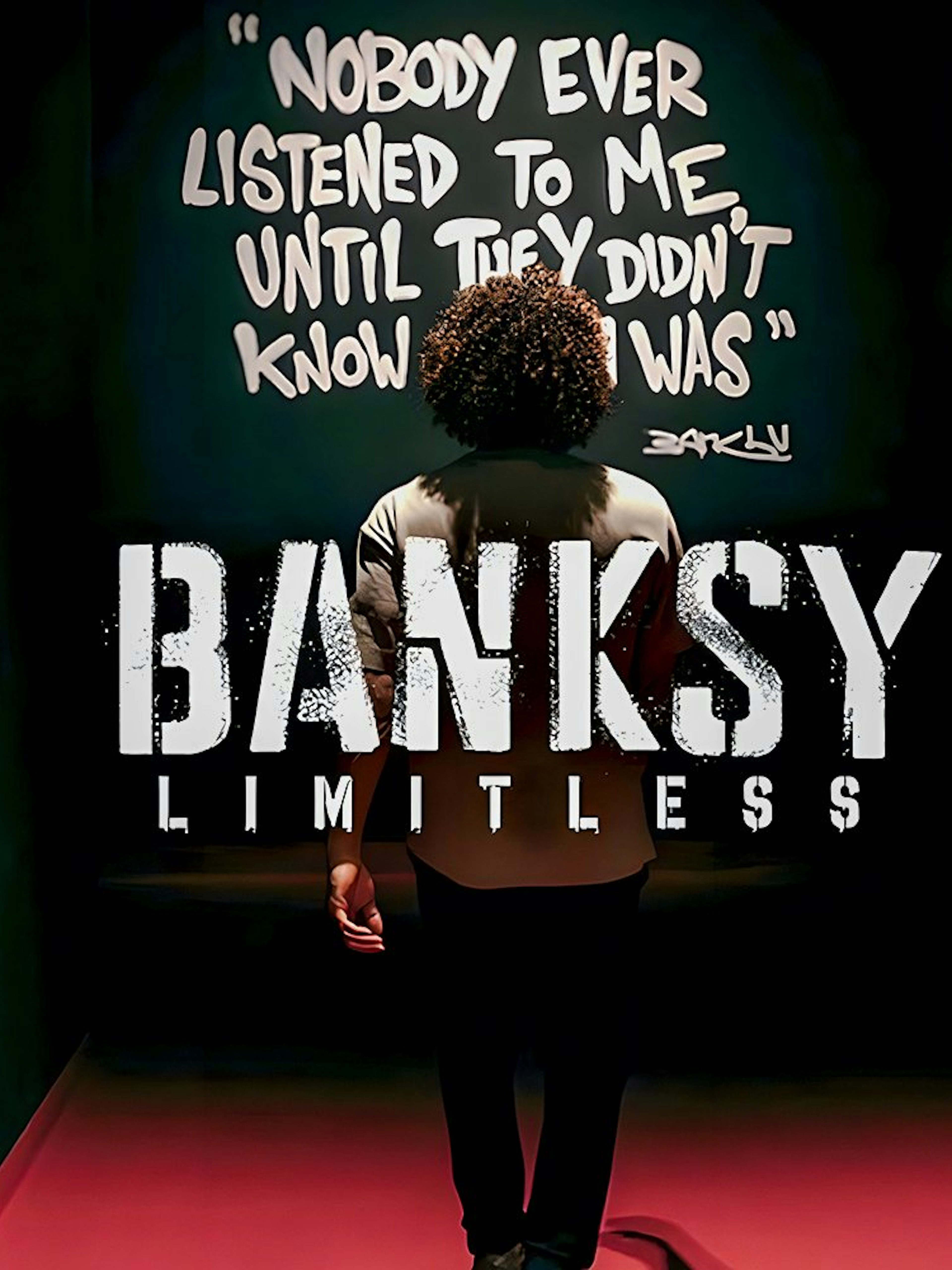 Visitor at Banksy Limitless exhibition viewing artwork with quote on wall.