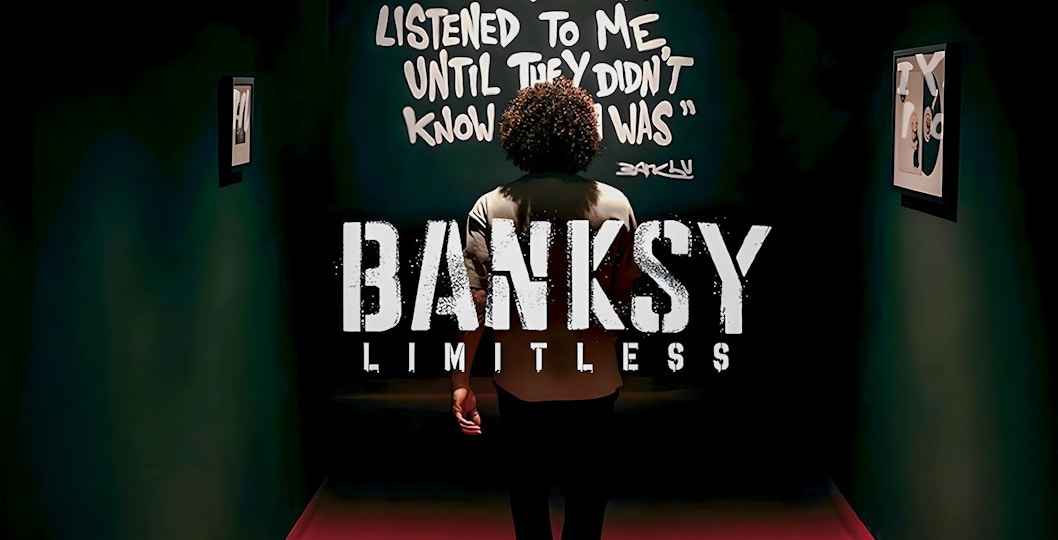 Visitor at Banksy Limitless exhibition viewing artwork with quote on wall.