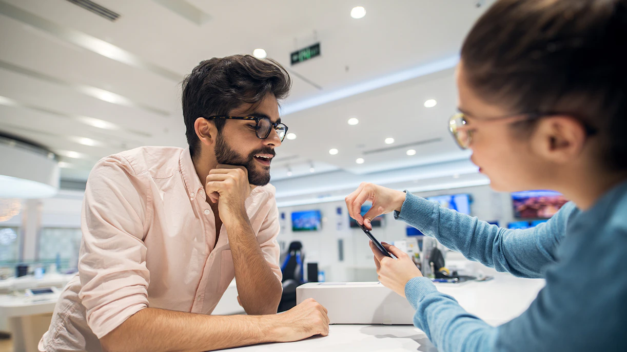 Customer being helped to convert prepaid card at Cash-to-Card kiosks