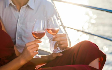Couple toasting with rose wine on a boat in Calanques de Cassis.