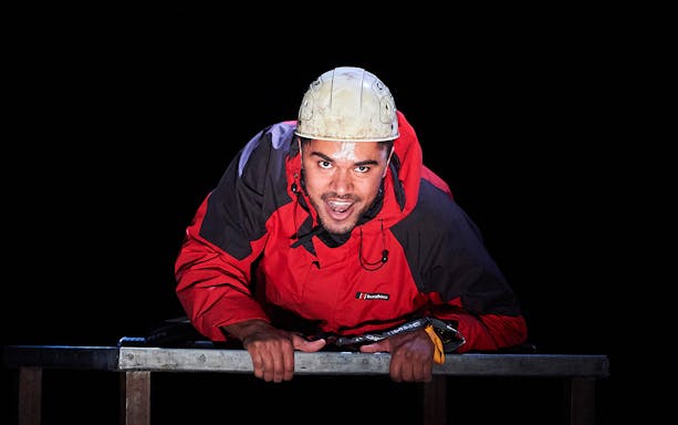 Man in red jacket and helmet during "Touching The Void" performance.