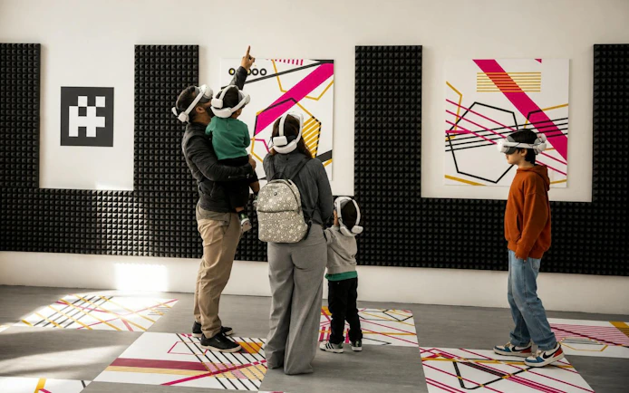 Visitors using VR headsets at Porto Legends exhibit with abstract art.