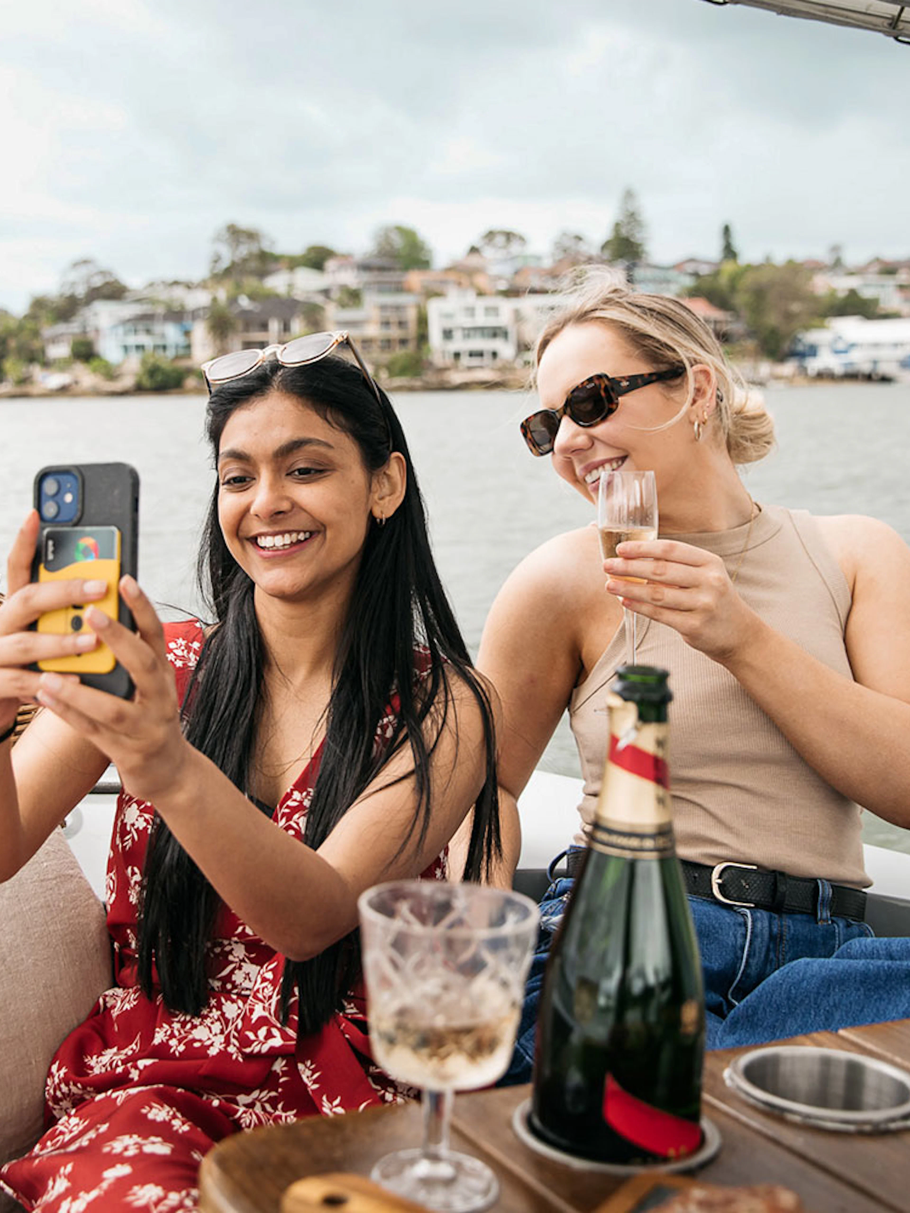 Friends enjoying a picnic on a self-drive electric boat in Sydney.