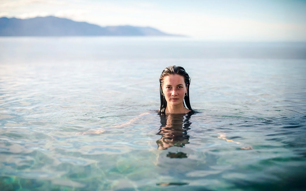 Guest enjoying Geosea Geothermal baths with ocean view in Iceland.