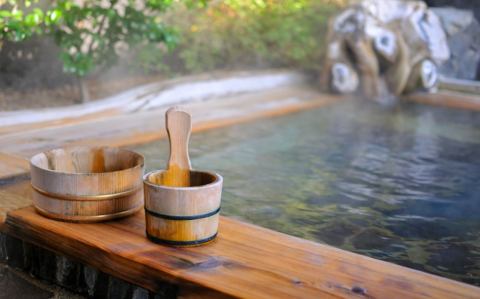 Wooden buckets by a steaming onsen in Kyoto.