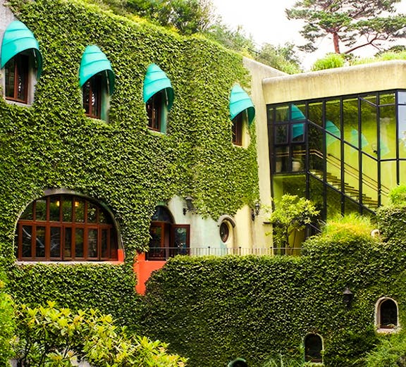 Studio Ghibli Museum exterior with ivy-covered walls and arched windows in Mitaka, Japan.