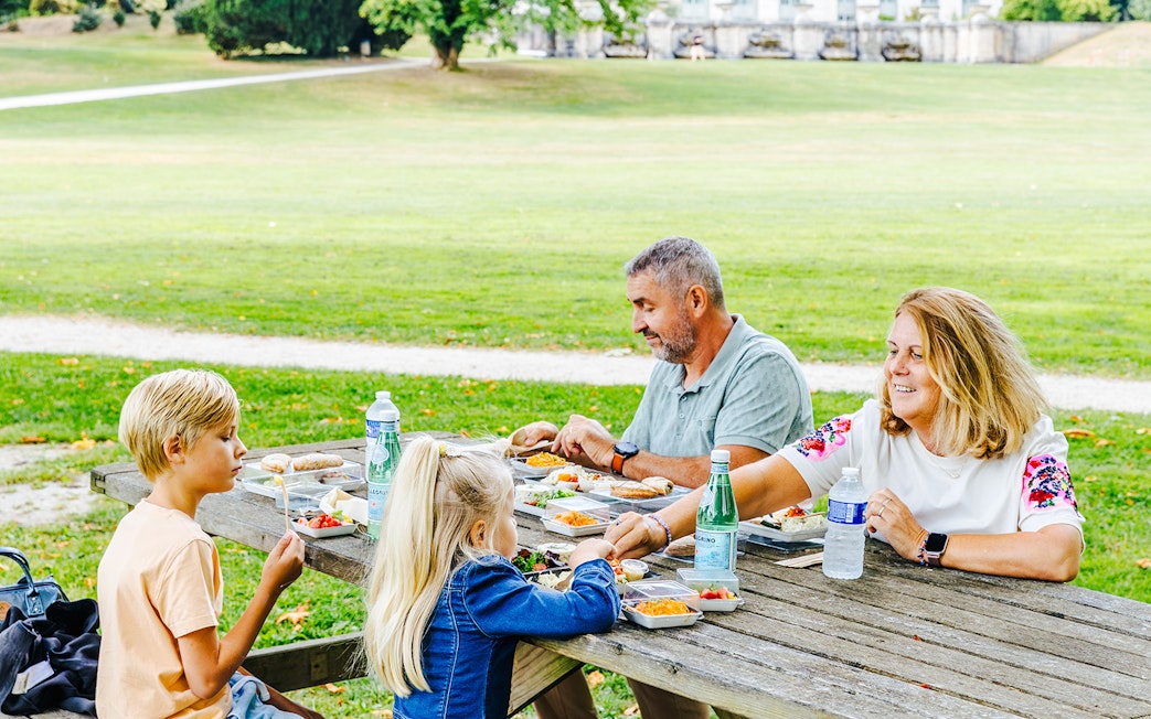Family enjoying a picnic at Chateau of Chantilly gardens.