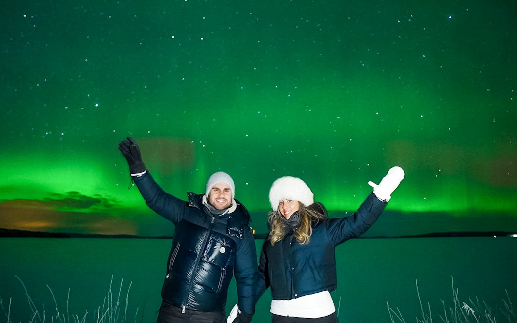 Couple enjoying Northern Lights in Tromso, Norway.