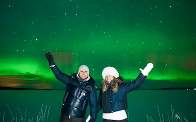 Couple enjoying Northern Lights in Tromso, Norway.