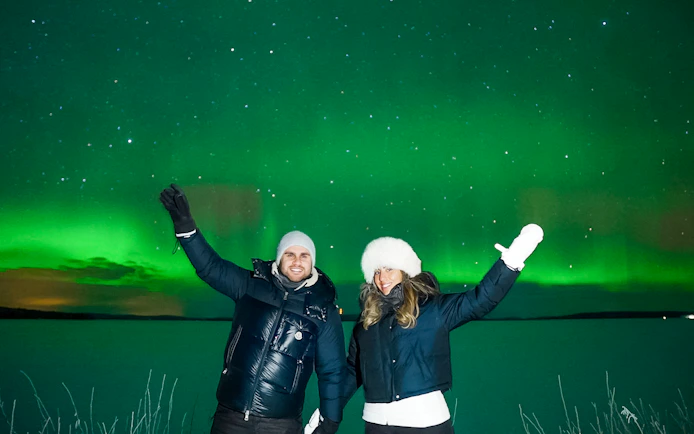 Couple enjoying Northern Lights in Tromso, Norway.