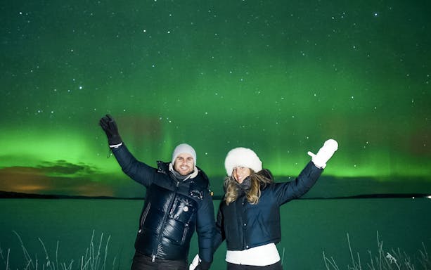 Couple enjoying Northern Lights in Tromso, Norway.