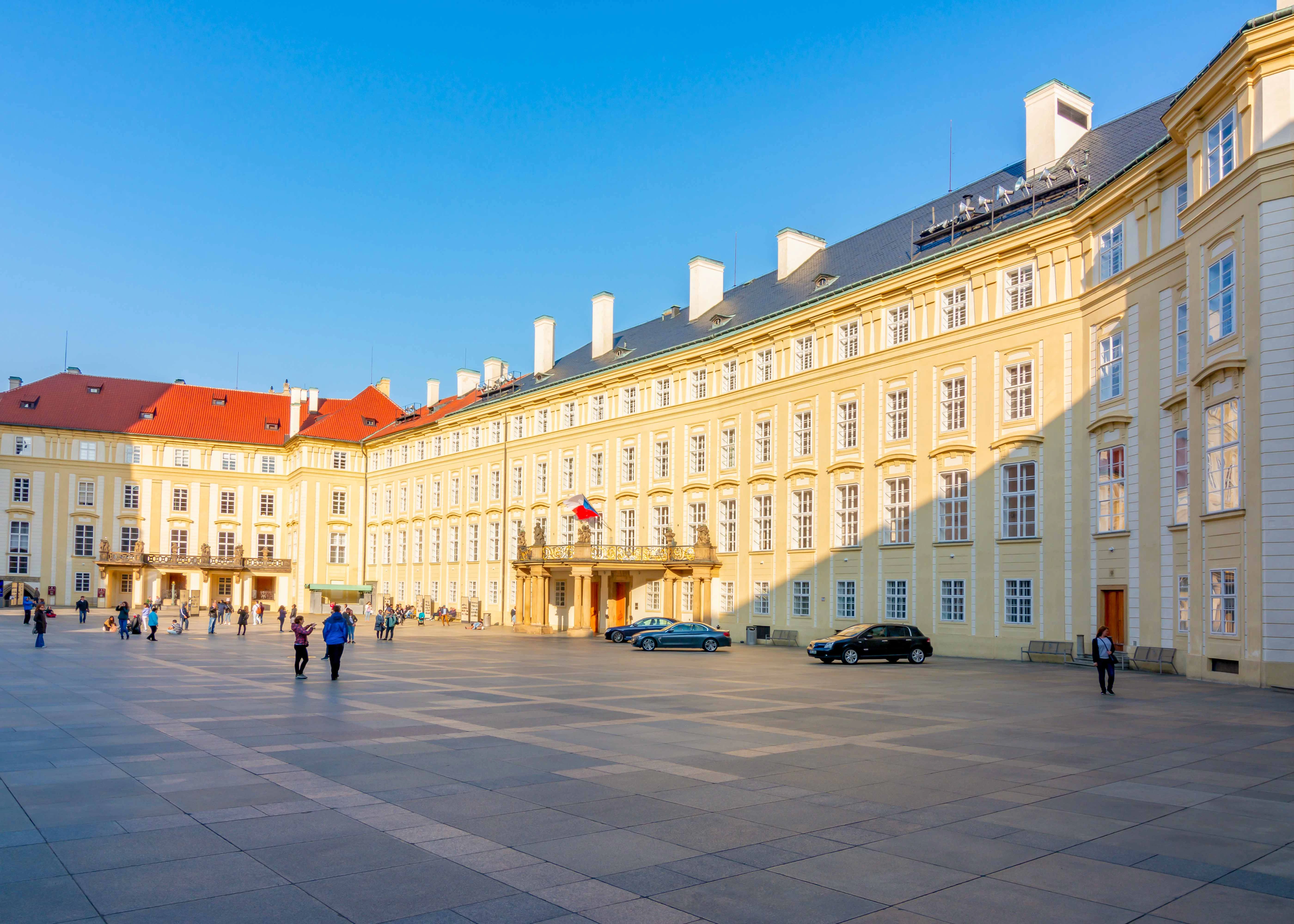 Old Royal Palace at Prague Castle with visitors in the courtyard.