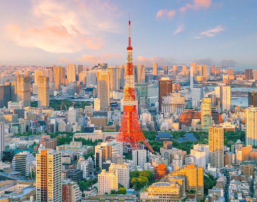 Tokyo Tower surrounded by cityscape at sunset, Tokyo, Japan.