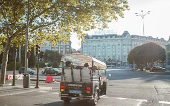 Tourists on an electric tuk-tuk tour near Palace Hotel in Madrid.