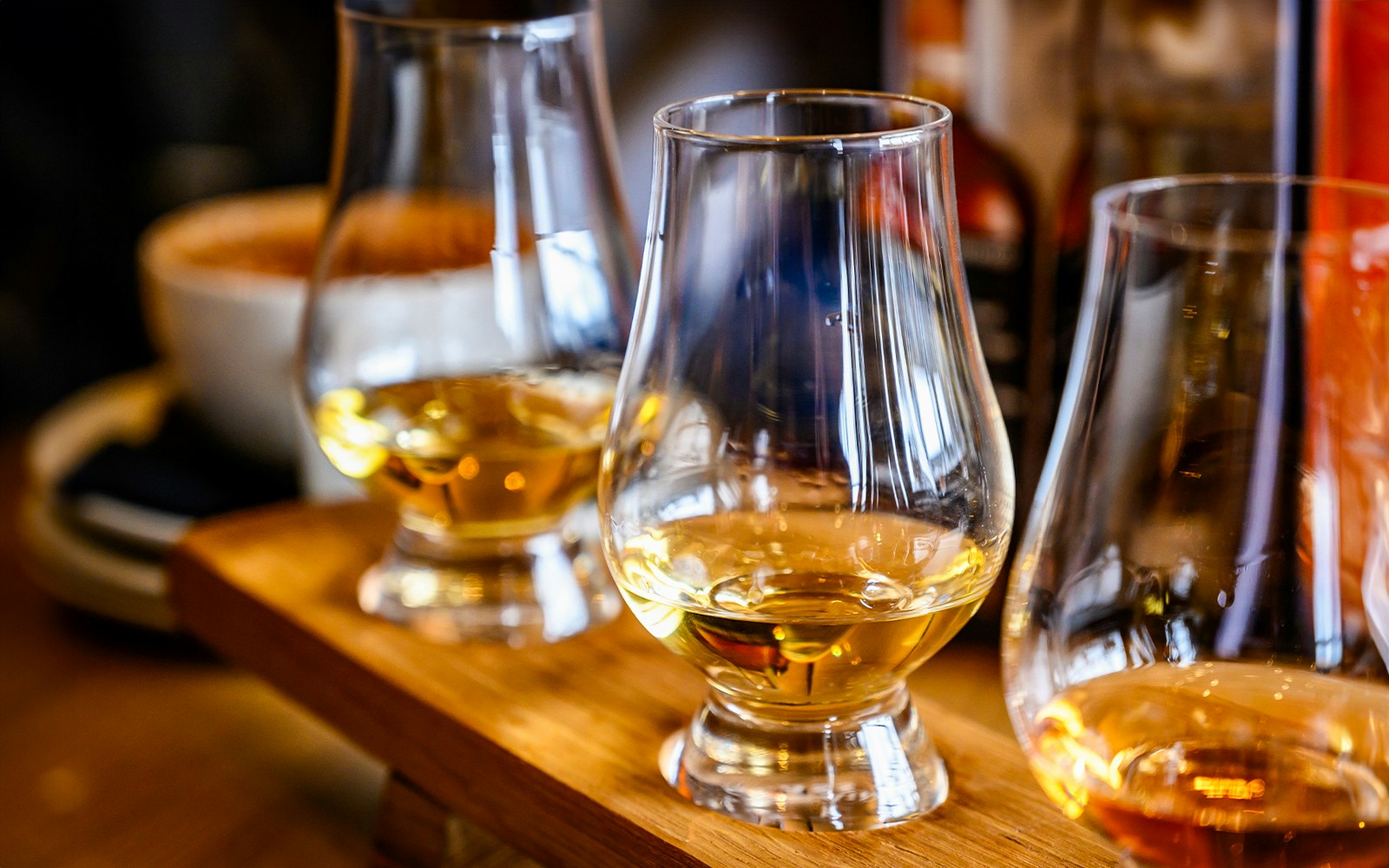 Whisky tasting glasses on a wooden tray during a tour in Edinburgh.