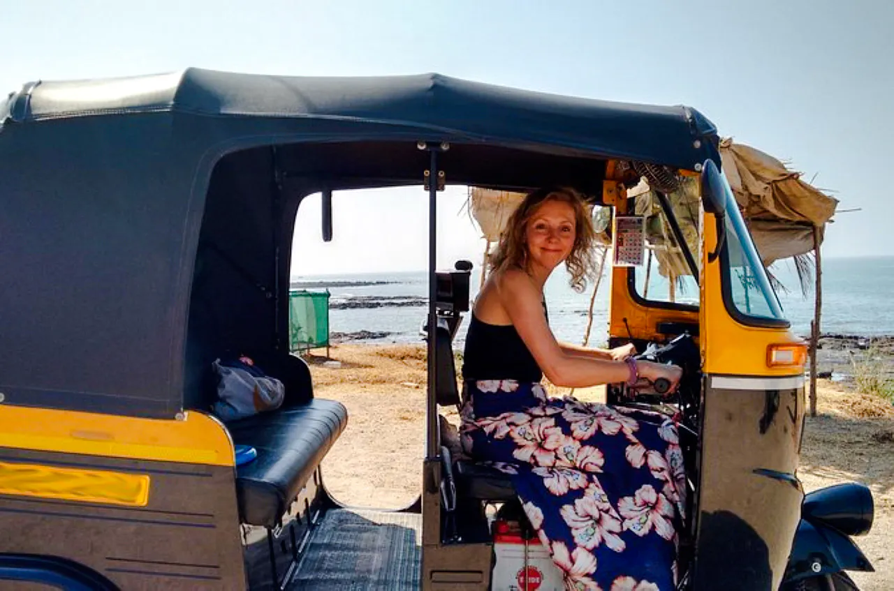 Person sitting in a tuk-tuk by the seaside, part of a private luxury tour from Delhi to Agra.