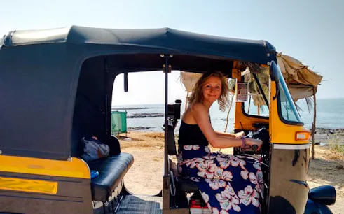 Person sitting in a tuk-tuk by the seaside, part of a private luxury tour from Delhi to Agra.