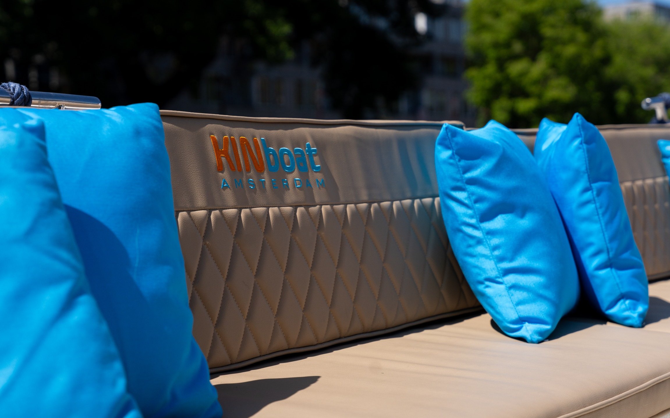 Open boat seating with blue cushions for Utrecht canal cruise.