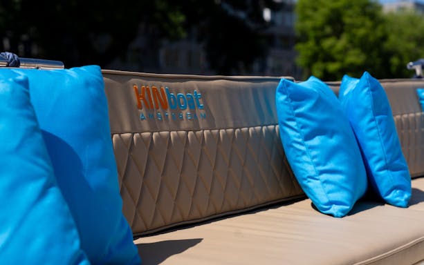 Open boat seating with blue cushions for Utrecht canal cruise.