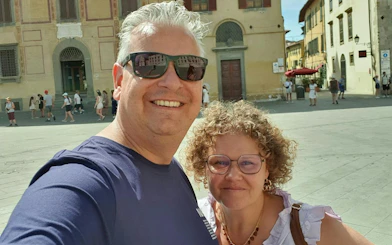 Couple enjoying a sunny day in Pisa's historic square during a self-guided city exploration game.