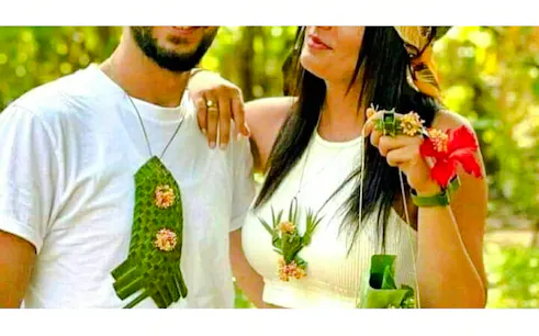 Couple wearing handmade leaf and flower accessories at a Zanzibar spice farm.